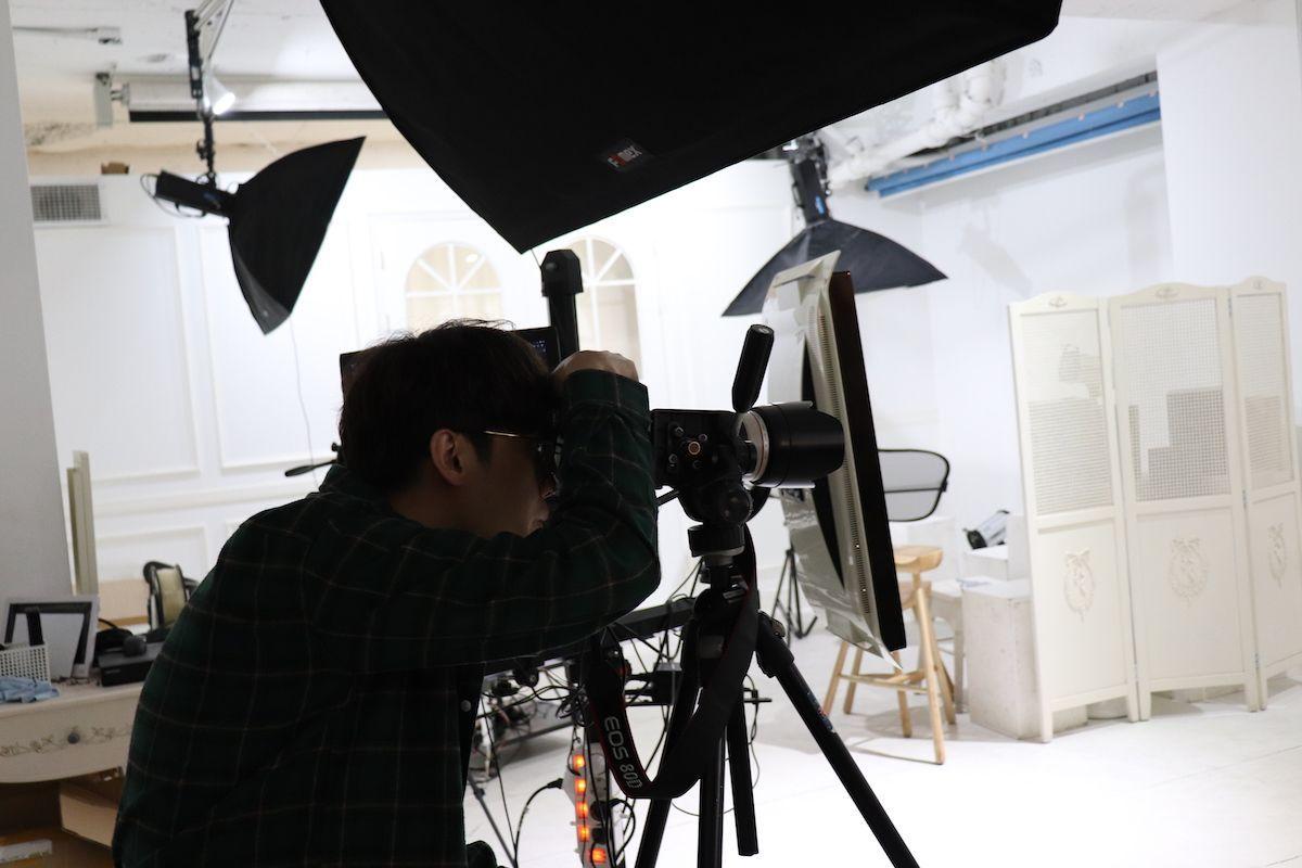 韓国の証明写真を撮影するフォトスタジオ、プロのカメラで撮影中の写真家の画像