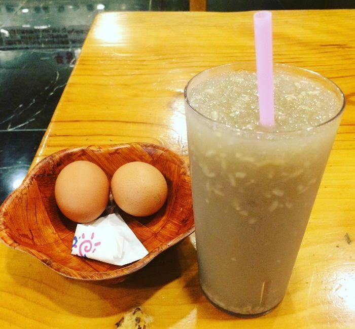 兩杯韓式米酒飲品放在地板上的圖像展示，鮮亮的色彩吸引眼球，是汗蒸幕的熱門飲品選項。