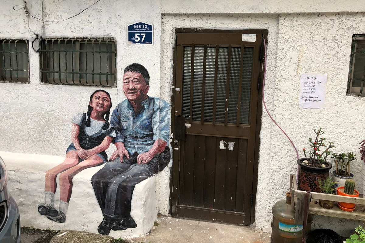 梨花壁畫村一幅父與女的壁畫，描繪了一種家庭温馨的畫面，在居民區的牆上呈現