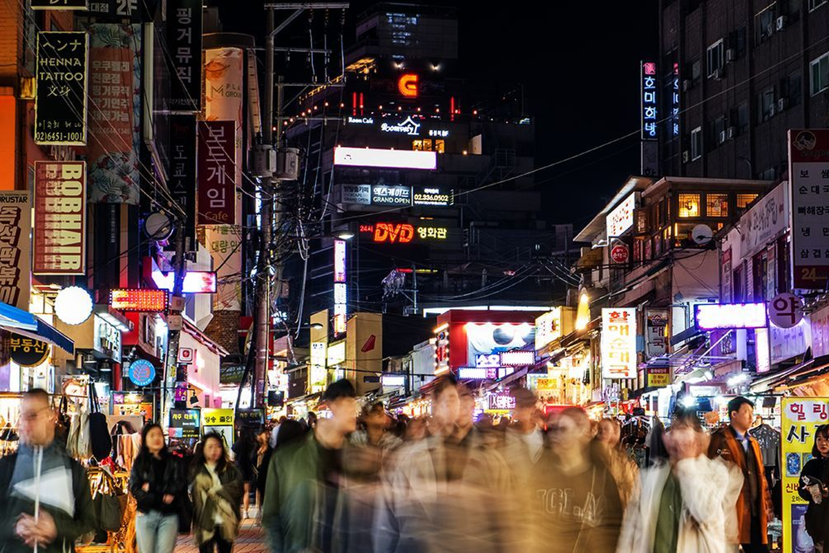首爾夜間繁忙的商業街，流動的夜生活和閃爍的招牌燈光