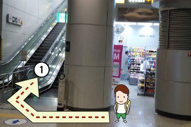 Hướng dẫn chỉ đường đi lên thang cuốn tại Sân bay Incheon Hàn Quốc với biển chỉ dẫn màu đỏ.