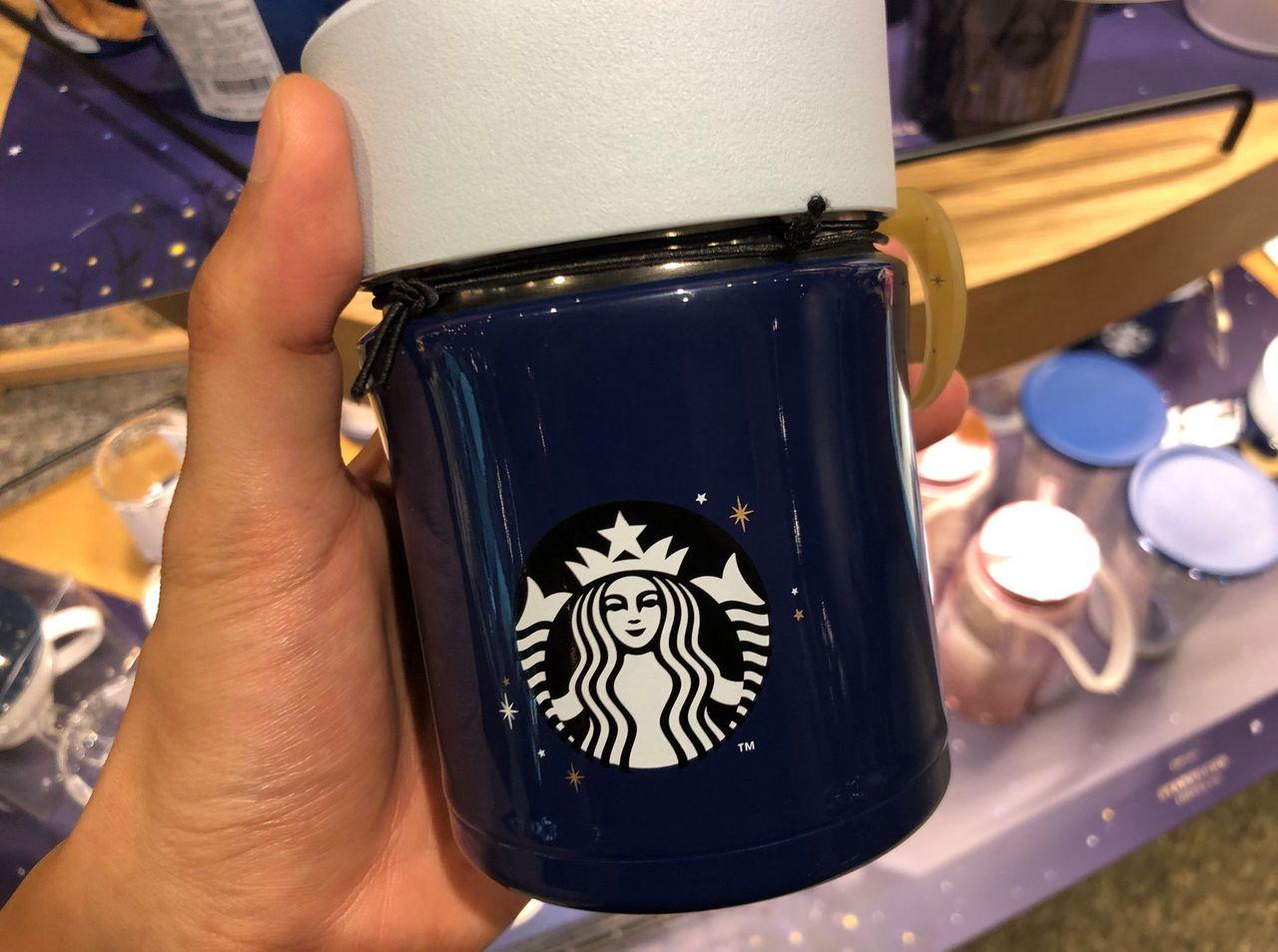 Тод, гараасээ барин байхдаа, 'Starbucks' хээтэй индего аяган дээр аргын эрхэм тоглолтой.