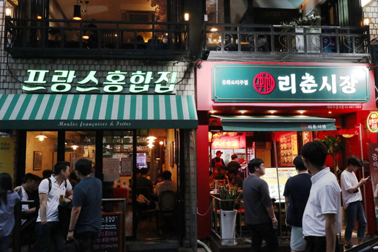 Devantures de restaurants sur Sha-ro-su-gil, avec des enseignes éclairées la nuit.