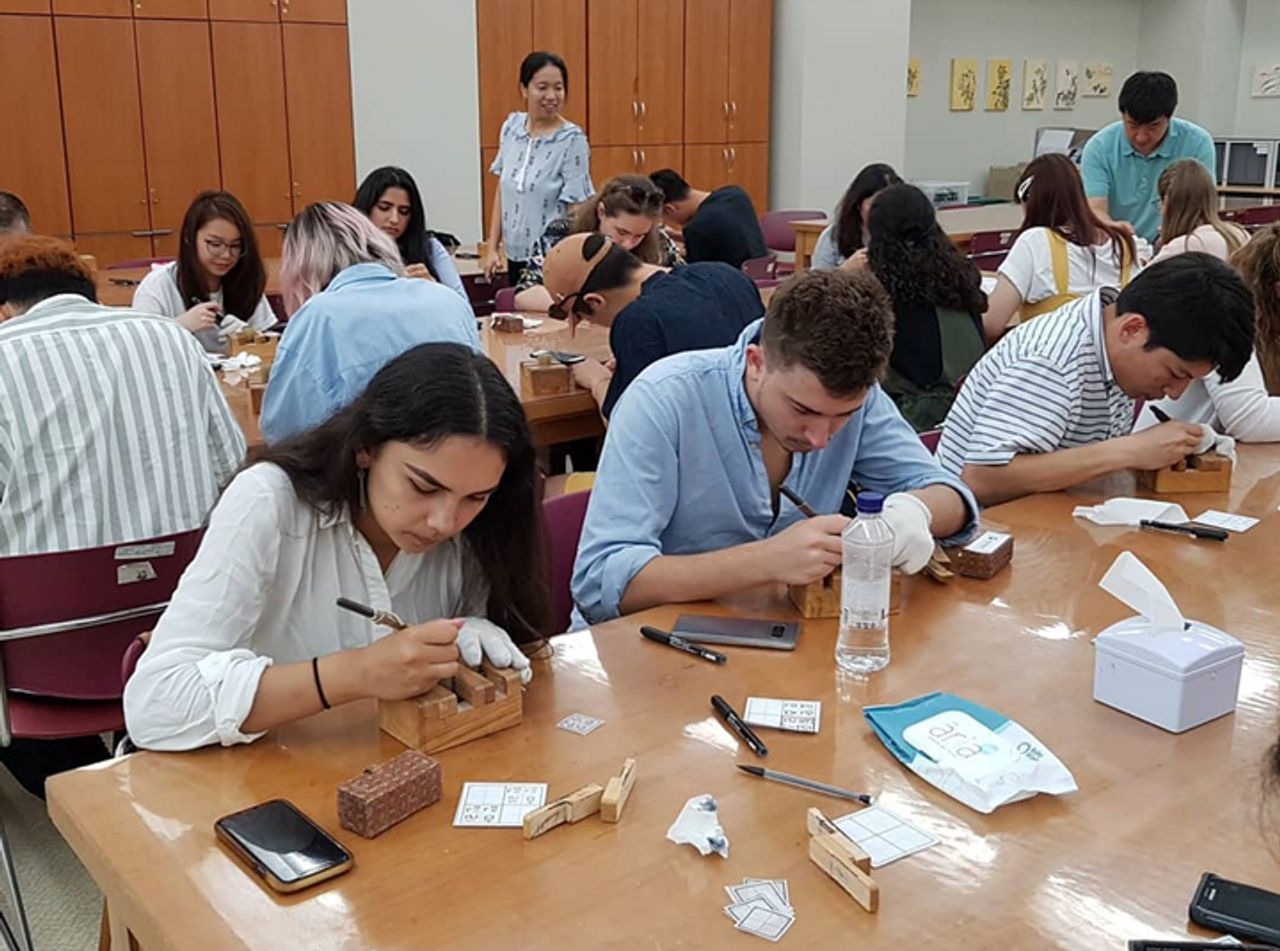 Groupe d'étudiants participant à une activité culturelle à l'Institut de langue coréenne de l'Université nationale de Séoul.