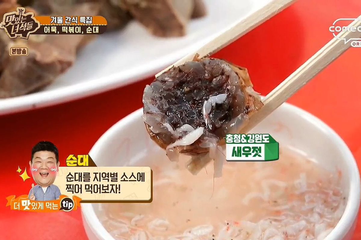 大塊韓式血腸沾上醬料，使用筷子夾起展示，標示搭配調味海鮮醬的吃法。