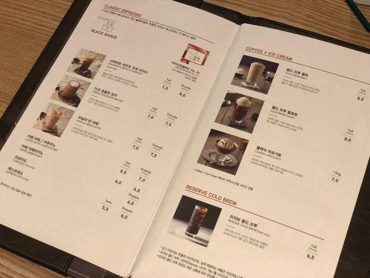 Assorted bags of different Starbucks Reserve coffee beans displayed on shelves.