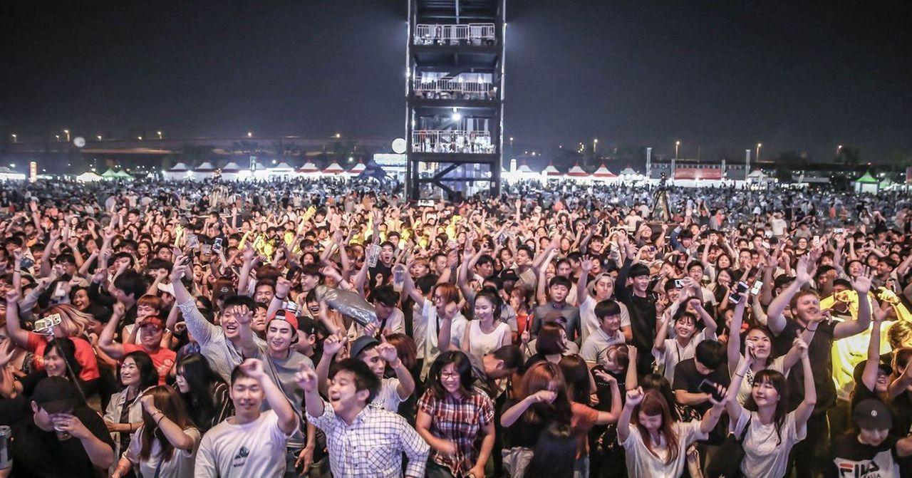 一個大型音樂節的現場，觀眾們聚集在舞臺前，享受音樂的狂歡與熱情。