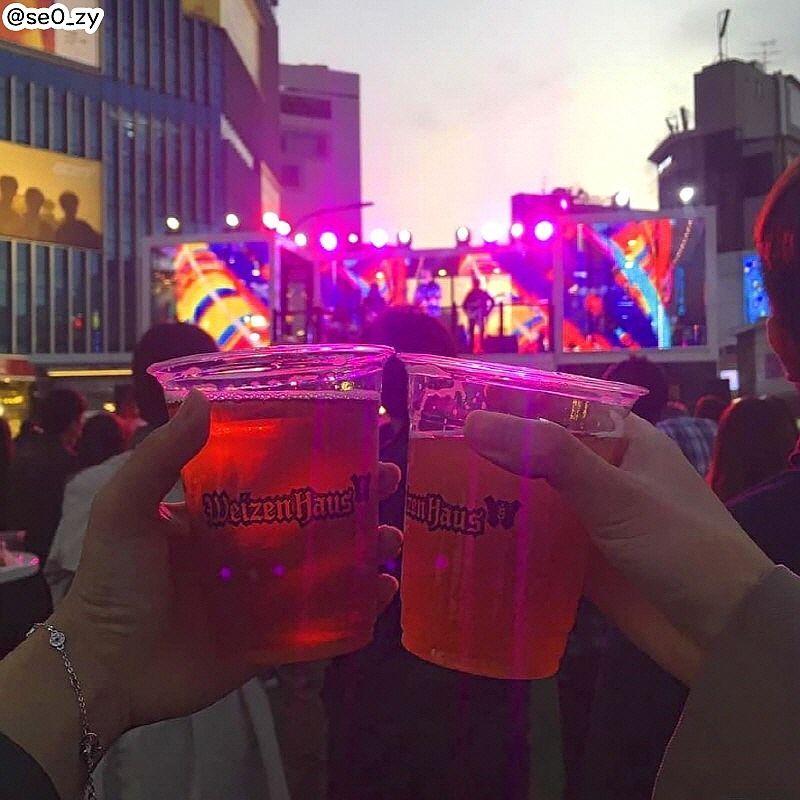 兩杯WeizenHaus啤酒在現場的燈光舞臺前舉起，象徵新村啤酒節的盛大慶典氛圍。