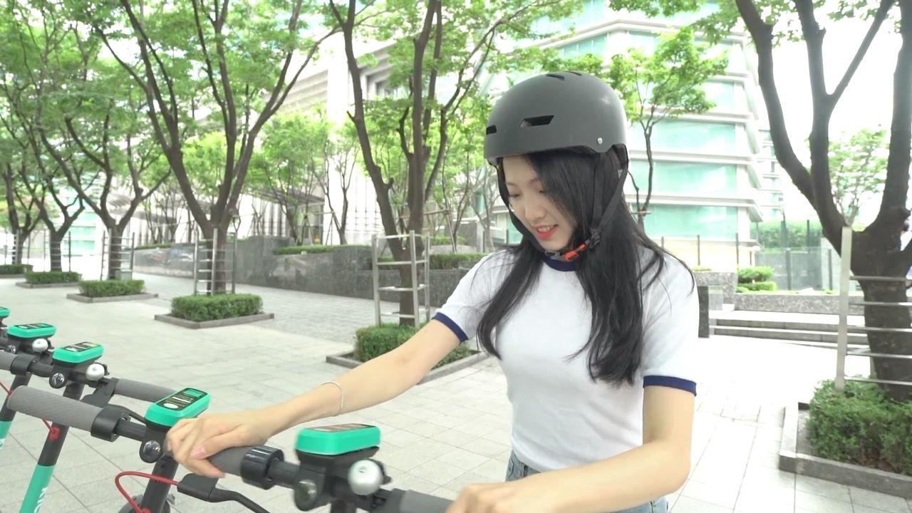 用户正戴著安全帽準備使用 KICKGOING 共享滑板車，一個安全騎行的有利展示。