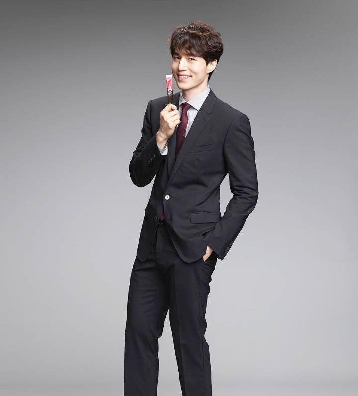 Uomo in completo con confezione di ginseng Jeong Gwan Jang in mano