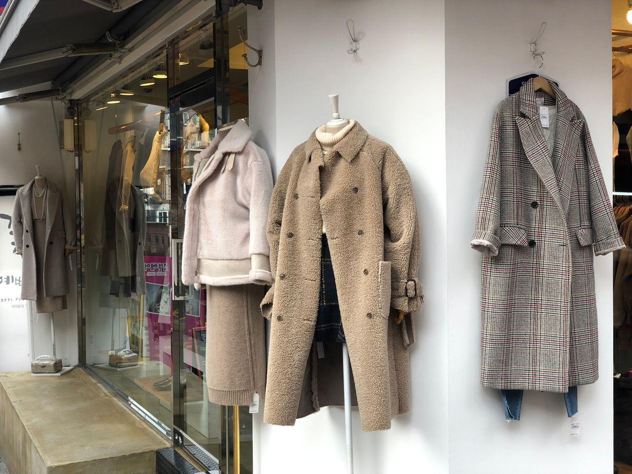 Cappotti da donna esposti su supporti all'esterno di un negozio in Corea