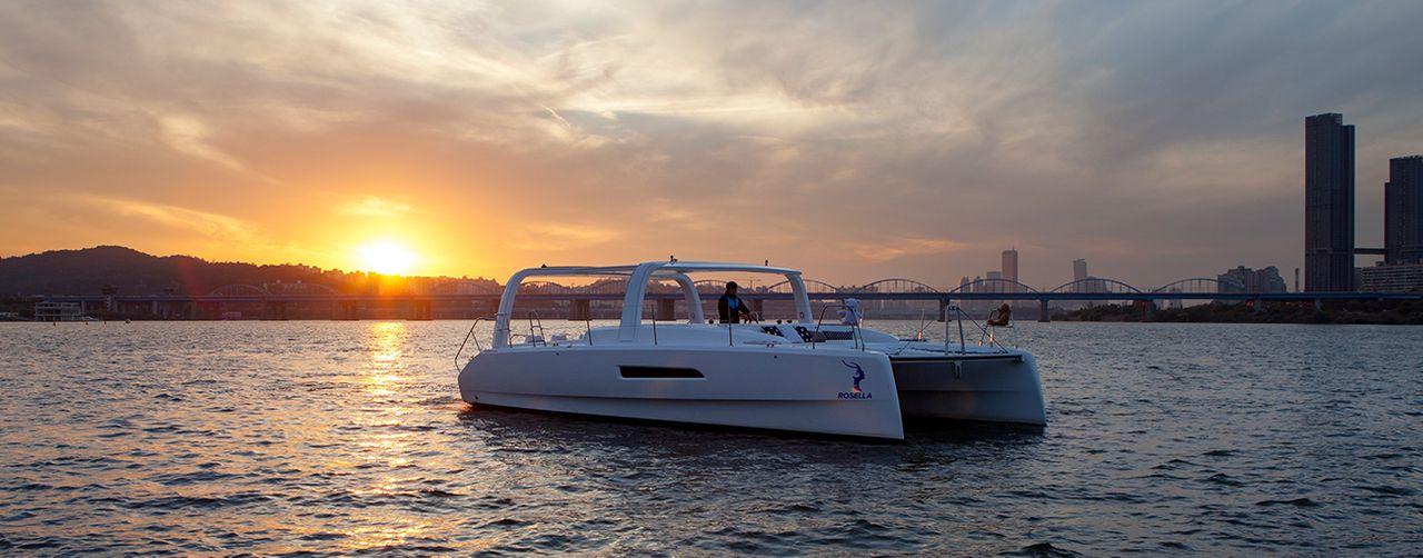 Vista esterna di uno yacht di lusso con persone che ammirano il panorama mentre navigano sul fiume Han.