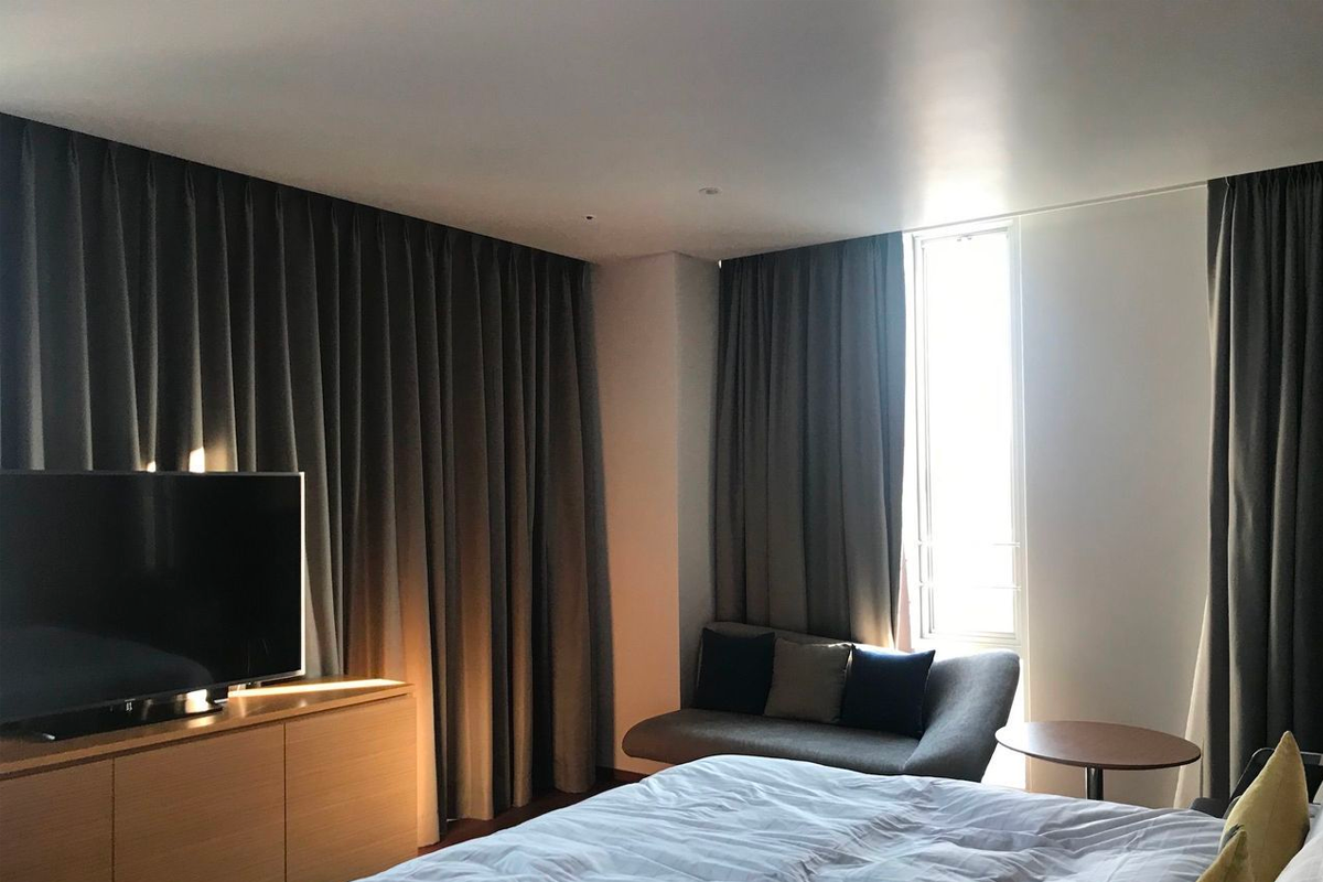 房間內，窗旁有沙發與電視設置，旨在提醒確認酒店是否在退稅名單內。