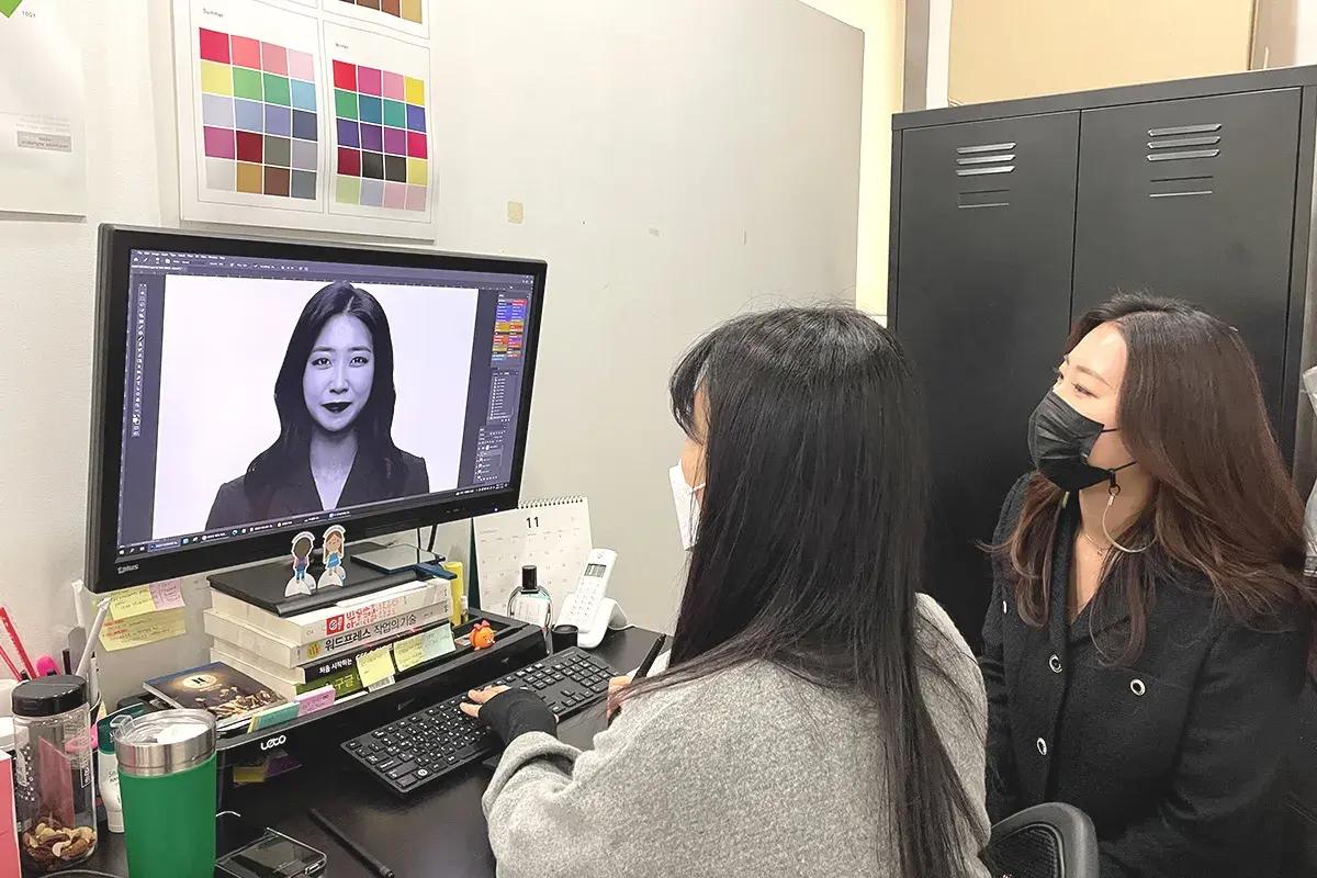 韓国の写真館で写真のレタッチを行っているシーン。コンピュータの画面には、証明写真のように見える画像が映し出されている。