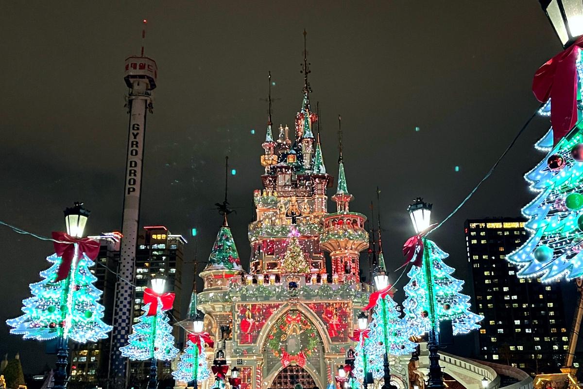 Замок в Lotte World украшен рождественскими огнями в ночное время