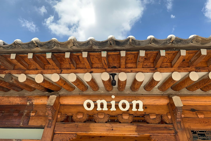 Onion咖啡廳外部建築，藍天背景下，韓屋的屋簷和外觀顯得尤為突出。