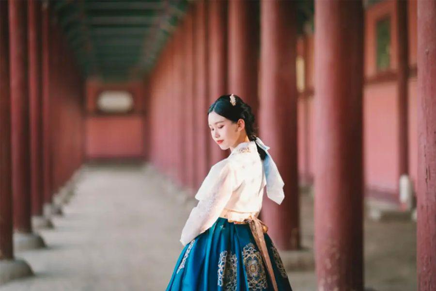 兩位穿著華麗韓服的女子在宮殿庭院拍攝