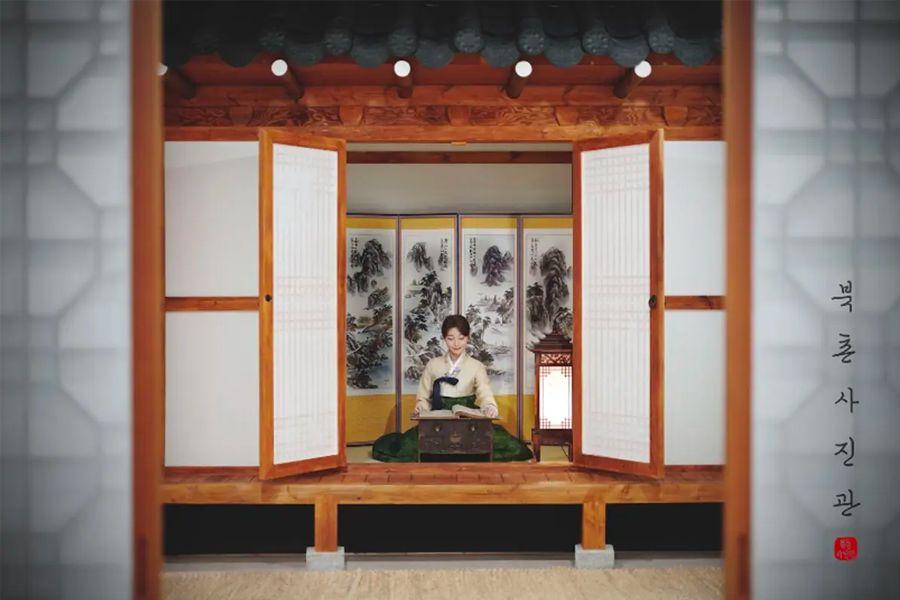 穿著韓服坐在傳統韓屋內的女子