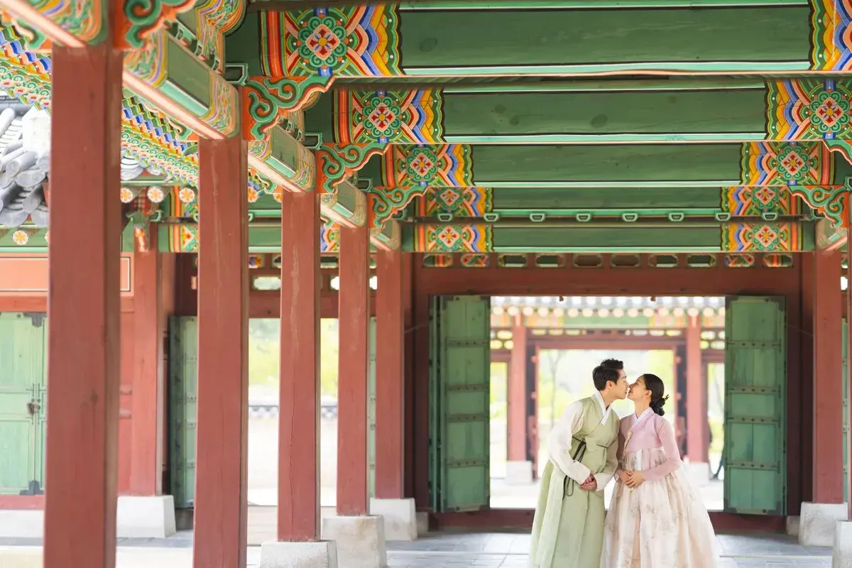 Traditional hanbok photoshoot with wooden Korean architecture.