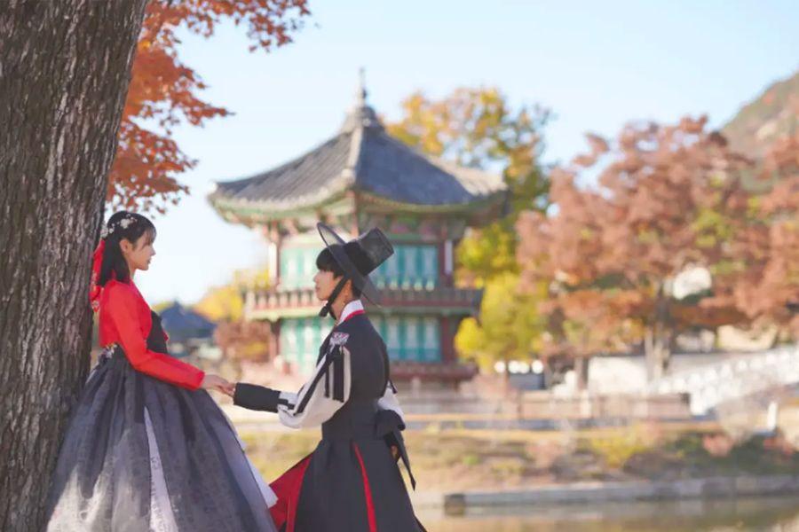 女子穿著藍色韓服在景福宮的柱廊拍攝