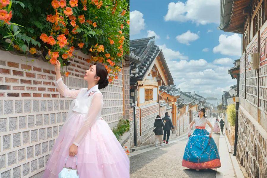 女子穿著韓服在韓屋村欣賞牆上開滿的花