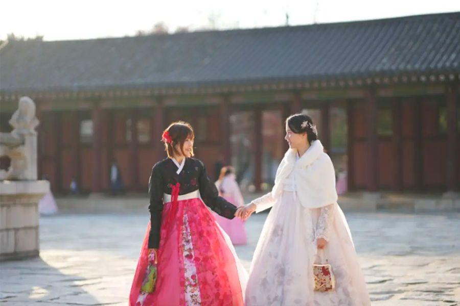 韓服女子在韓國傳統門口，背景是古色古香的圍牆