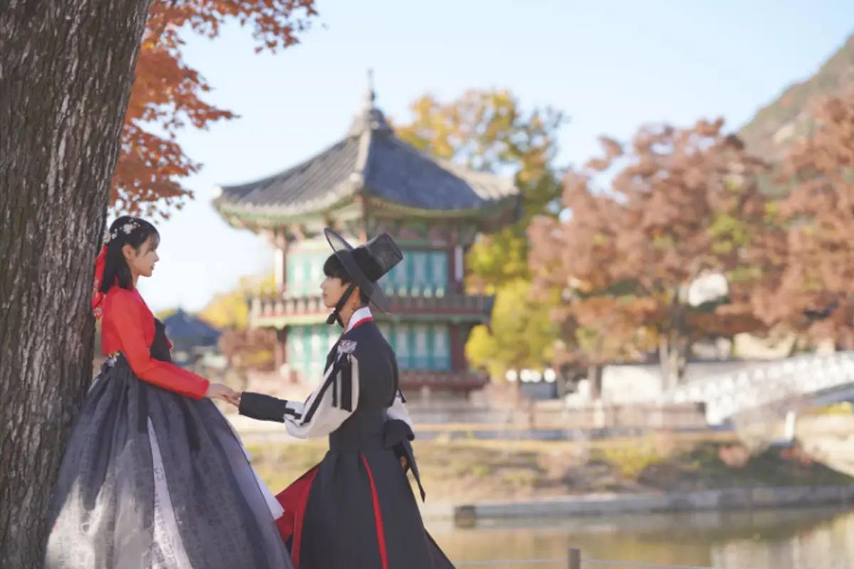 Outdoor photoshoot showcasing hanboks worn at a historic Korean site.