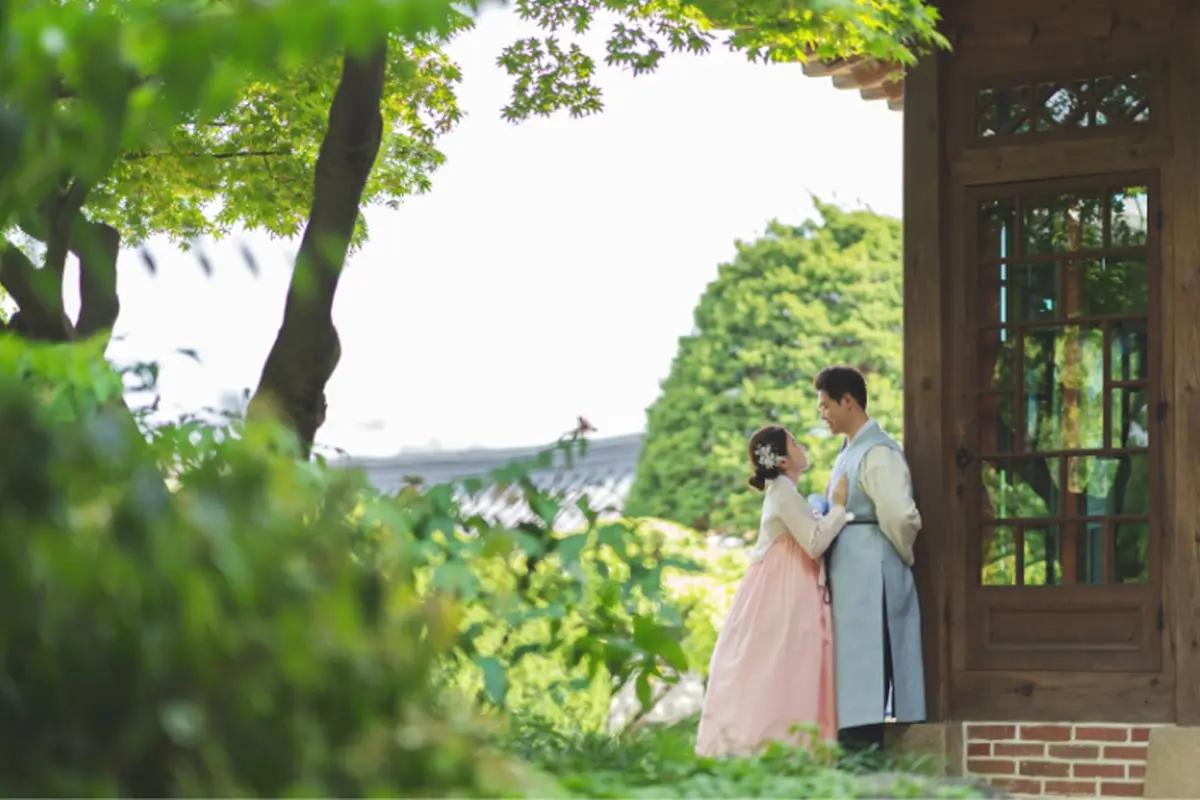 Person in hanbok admiring traditional Korean architecture at Bukchon Hanok Village.