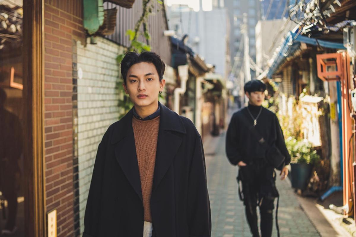 韓國首爾都市一角，黑色服裝配搭的時尚人士行走於復古背景建築，展露自信風采。