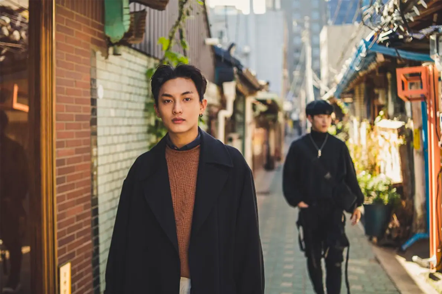 兩名男子在首爾的街道上漫步，背景為韓國的傳統建築