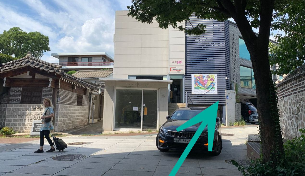 The path towards Tea Therapy with a modern building in the background and traditional Korean architecture on the left.