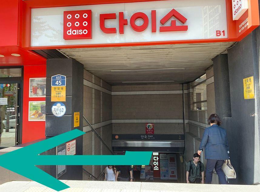 Entrance to Anguk Station with a sign above reading Daiso in Korean and English.