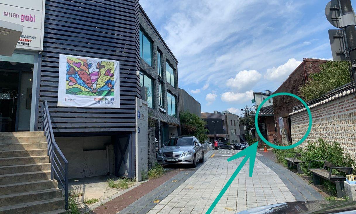 Narrow alleyway leading to Tea Therapy with a visible signboard on the wall.