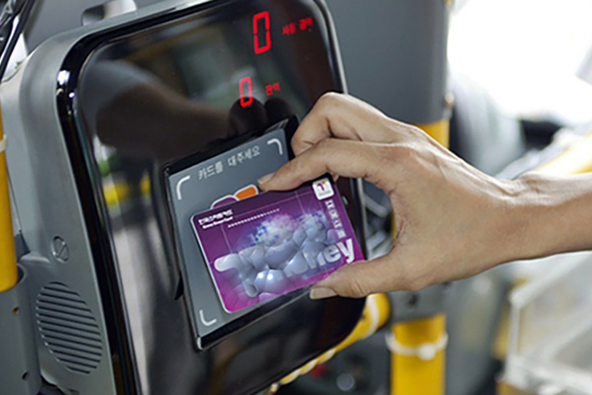 韓国の公共バスのカードリーダーに交通カードをかざす様子。交通カードを使って電子決済を実行しています。