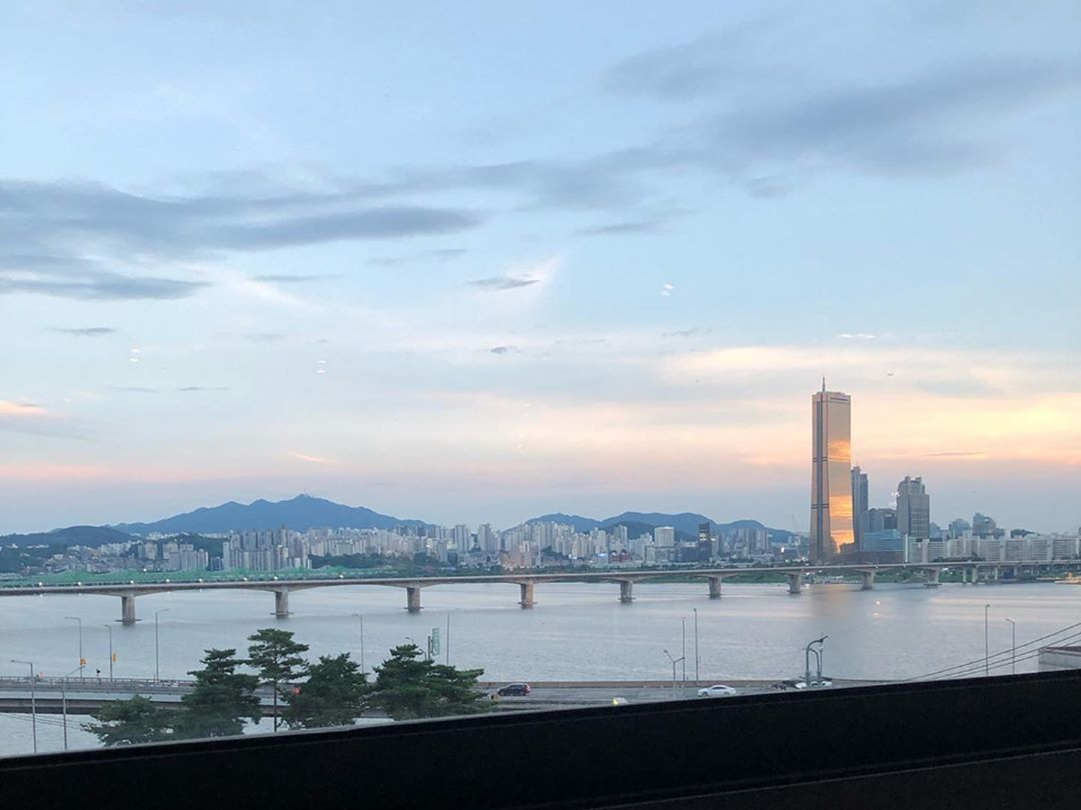 Panoramic view of the Han River and the iconic 63 Building at sunset from I.O.U Restaurant in Seoul.