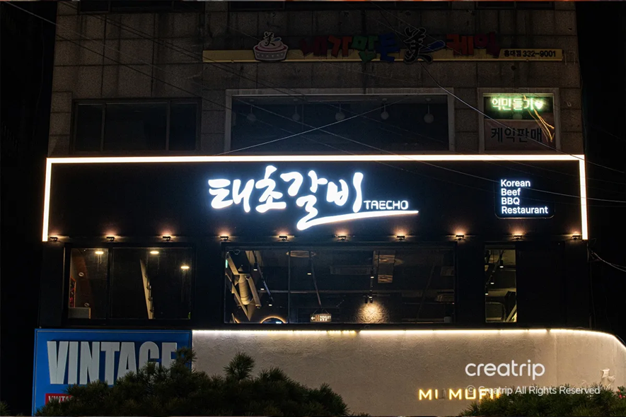 太初排骨餐廳的外觀，夜晚的燈光下，白色的招牌閃閃發光，吸引著食客們來此品嚐韓國燒烤的美味盛宴。