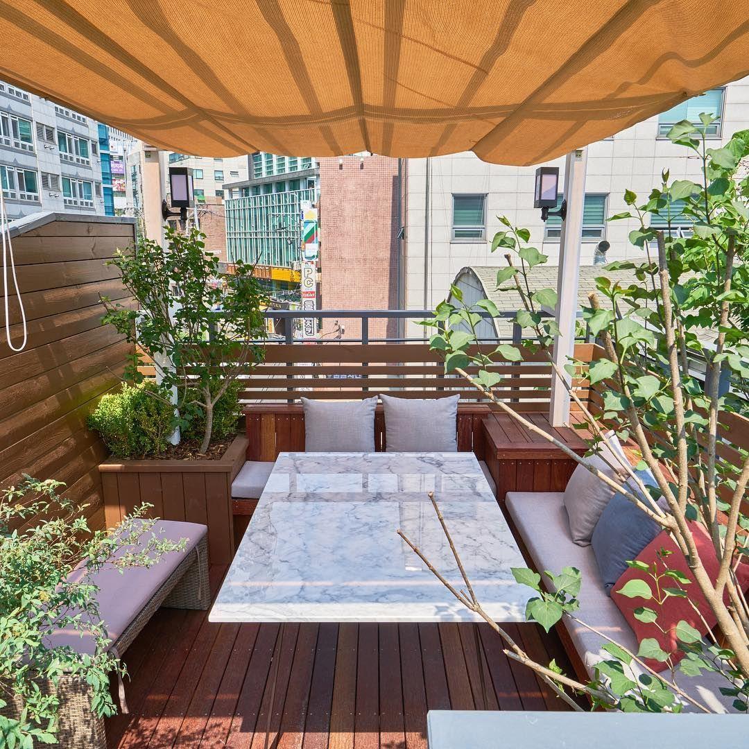 ソウル江南のピンクソル740の屋外テラス席。現代的なデザインのテーブルと木々に囲まれたリラックスしたスペース