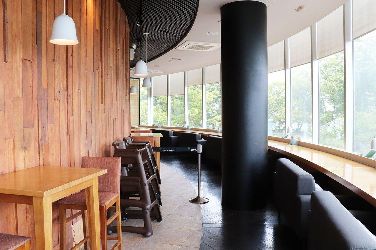Nソウルタワー内にあるダイニングエリア、明るい木材のインテリアと開放的な窓が特徴