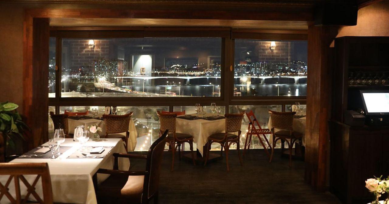ソウル、IOUレストランの内部。おしゃれなインテリアと漢江が見える窓側のテーブル