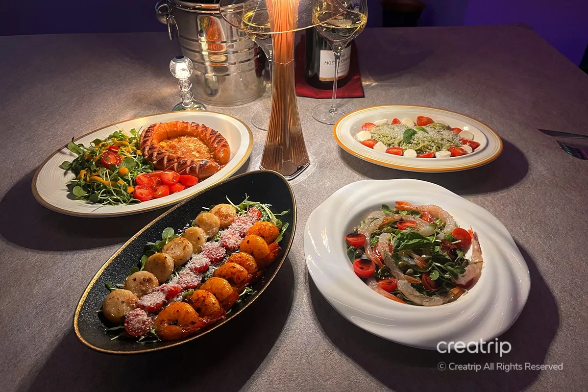 Kemistri的美食盛宴，餐桌上有各式各樣的菜餚，包括飾有西紅柿和香草的香腸，色彩繽紛的新鮮美食，讓人垂涎欲滴。