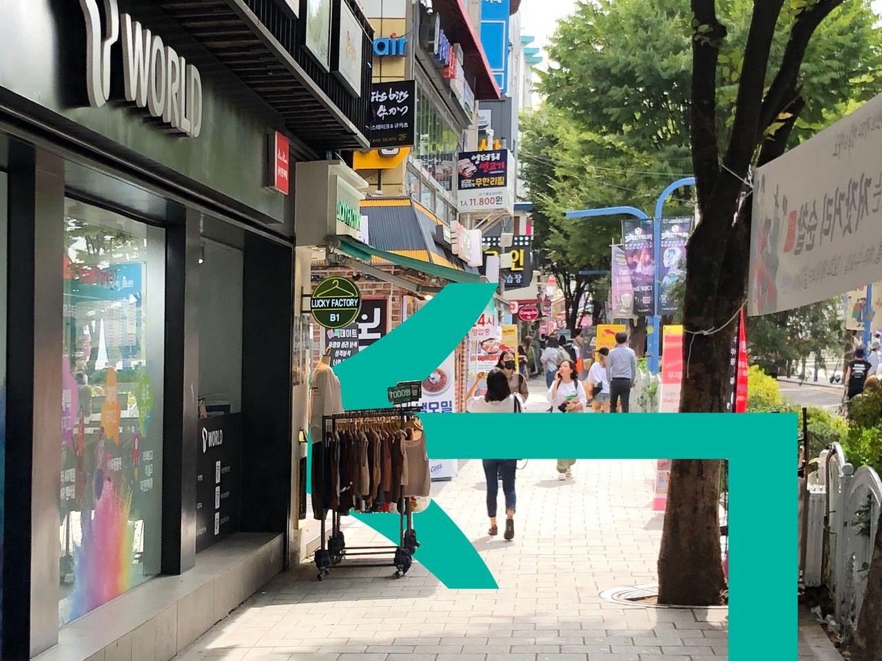 賑やかな通りの商店街と歩道に並んだ看板の光景