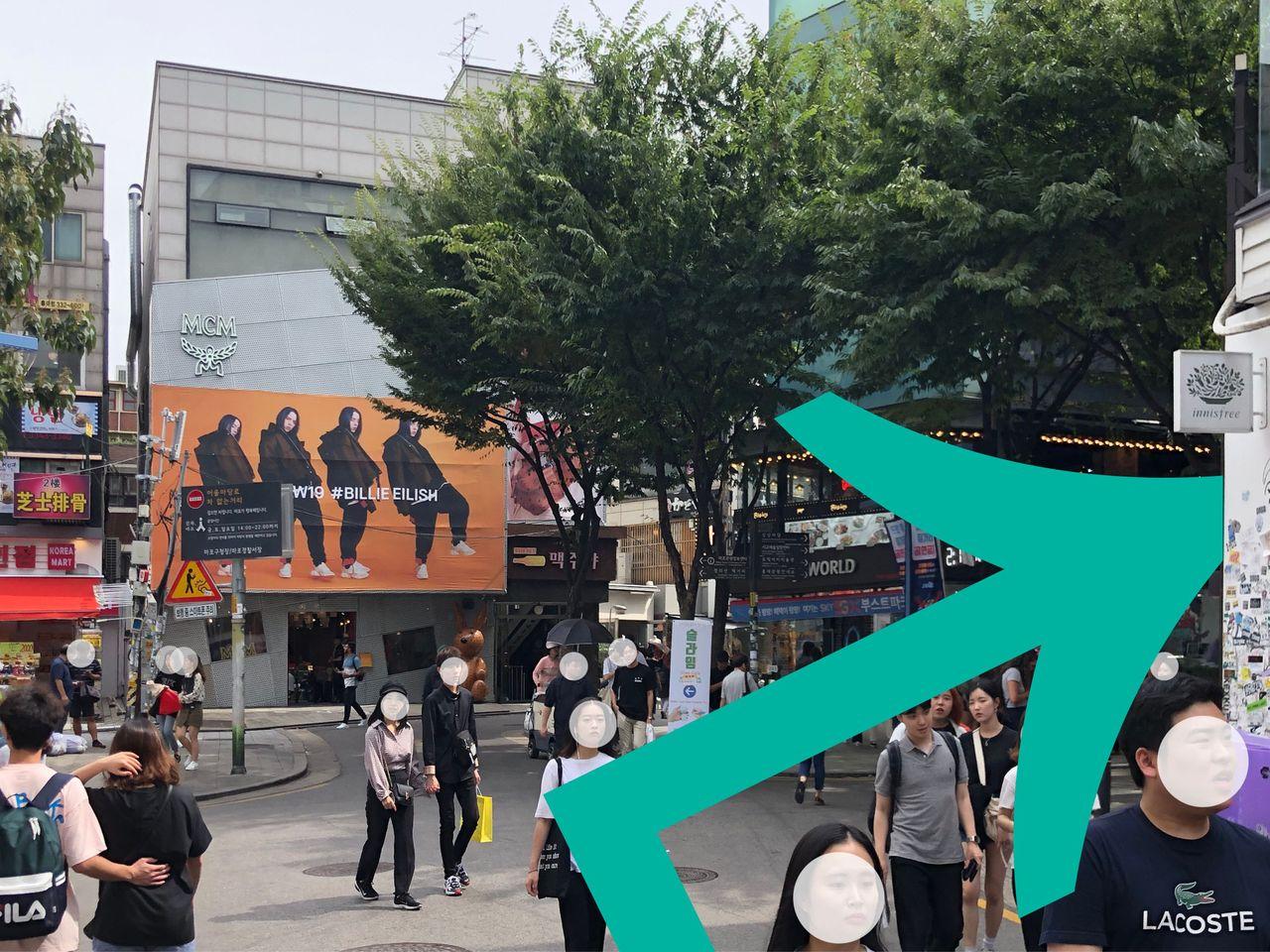 ビリー・アイリッシュのポスターが描かれた建物とその周辺の繁華街