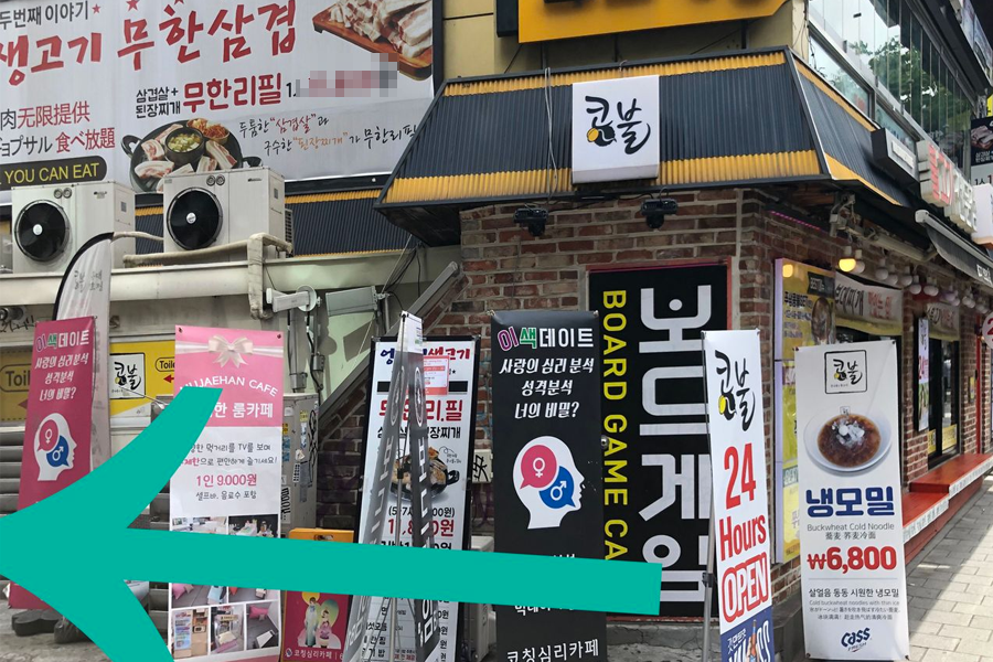 通過Olleh前的小巷轉左，街道旁充滿各類店鋪與指示牌，引導至弘大美食點。