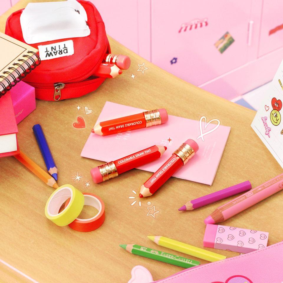 IT'S SKIN推出的色彩唇釉鉛筆，擺放在裝飾有心形貼紙和筆記的桌面上。