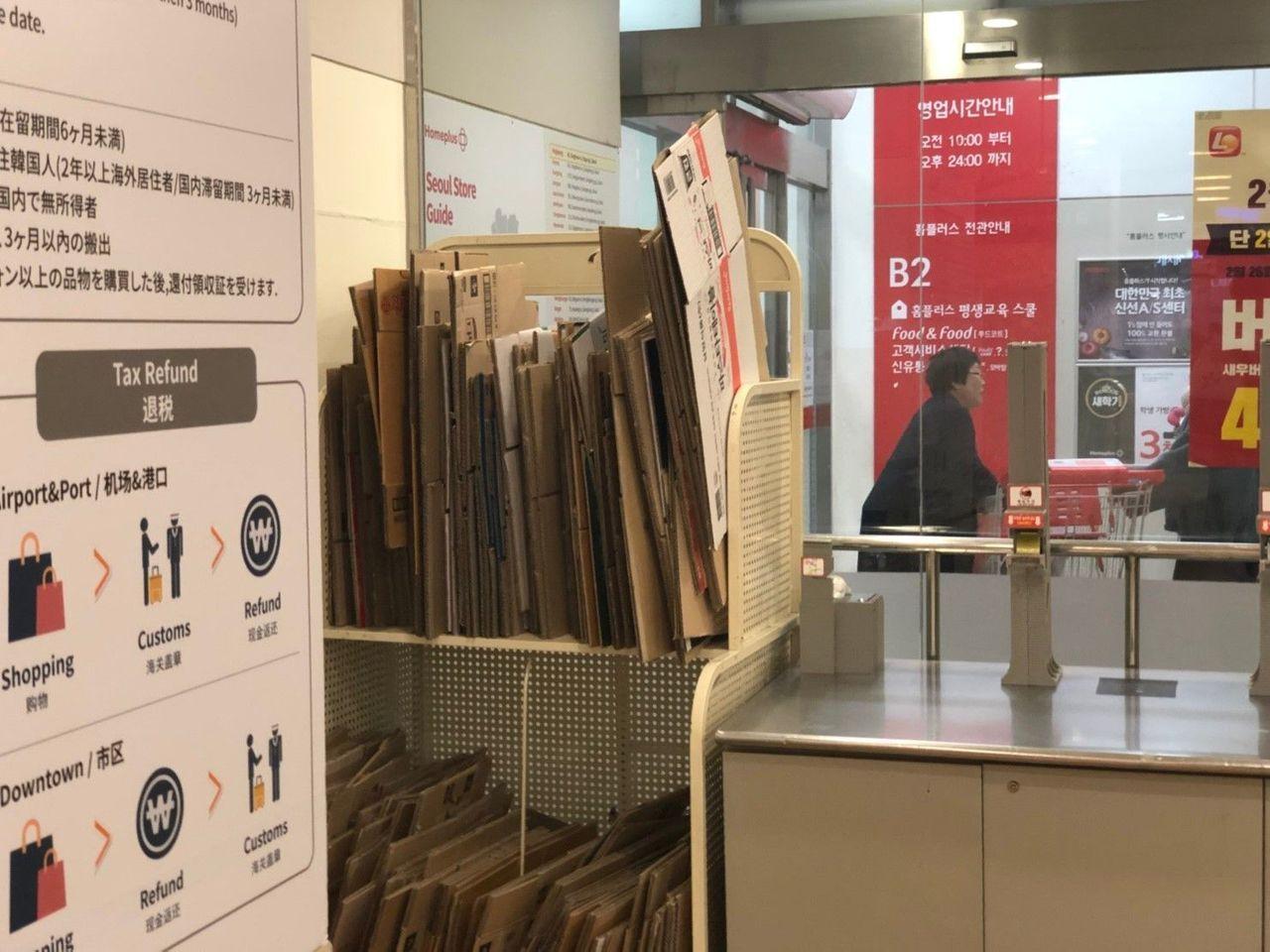 韩国超市内的纸箱回收区标有退税及购物指南。