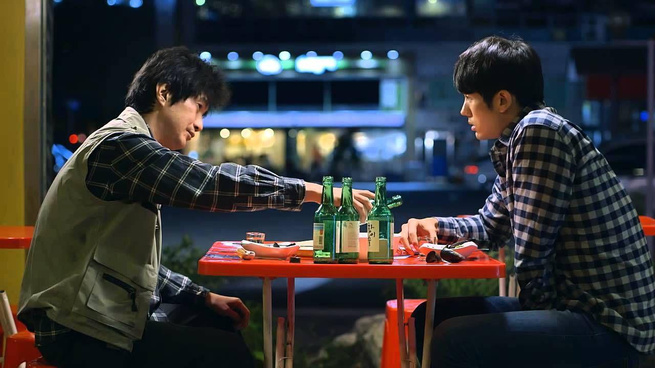 晚上在户外桌子上喝烧酒的韩国男子