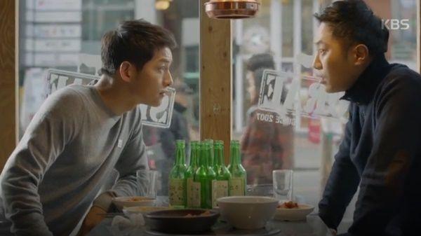 室内餐厅中正在享用食物和烧酒的韩国男子