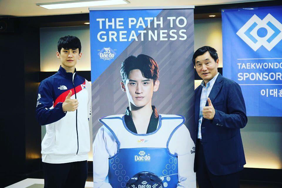 韓國跆拳道運動員與宣傳海報合影