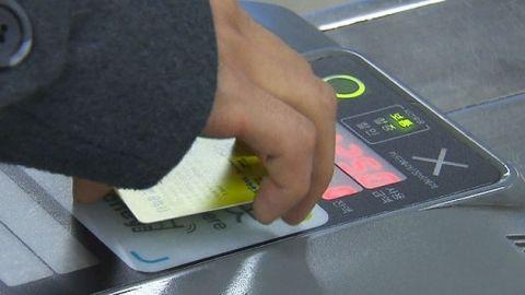 首尔地铁票卡刷卡机近拍，乘客正在刷卡进站。