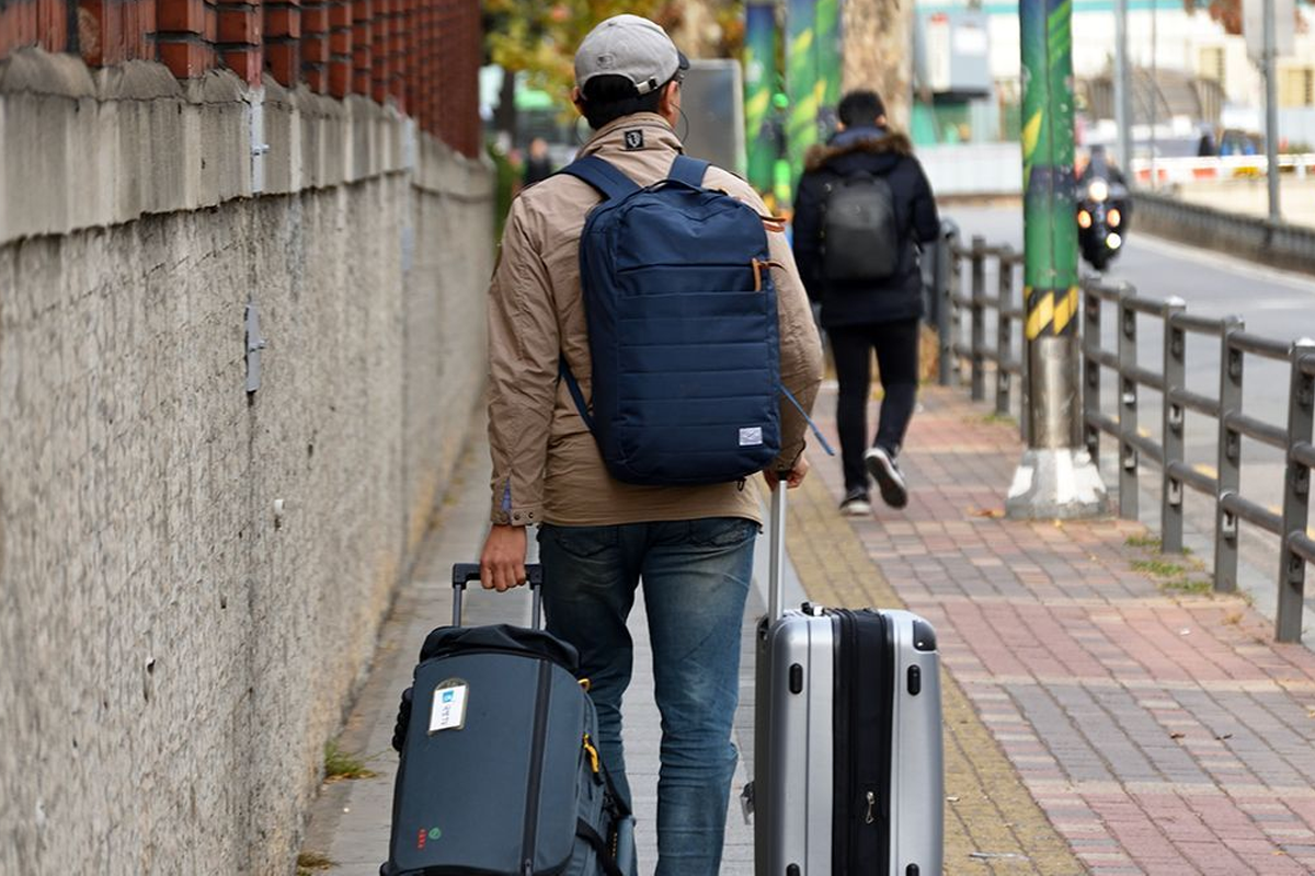 背著行李的旅客，象徵著移居和旅行的無限可能。